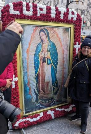 Celebrants carried a banner of Our Lady of Guadalupe, which is ringed with red and white roses, more than two miles from the parish that bears on W. 14th St. to St. Patrick’s Cathedral. Photo: Brian Berger