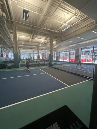 Picklers engaged in an intense one-on-one rally at Life Time’s PENN 1 location. Seven new indoor courts are now available there, for members who have a “Premier” plan.