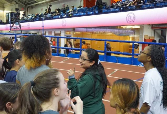 Runners on the St. Vincent Ferrer track team gather round their beloved coach Olga Ladino. She coached international atheletes in her native Colombia. Photo: Gladys Gerbaud