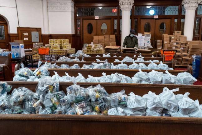 Food packages are organized at Evangel Church in Long Island City, to be distributed by New York Cares volunteers to those in need.