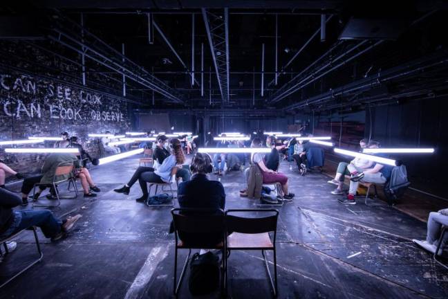 People sit in socially-distanced pods under the lights at Donmar Warehouse in London’s West End. The show is headed to the Daryl Roth Theater April 2. Photo: Helen Maybanks