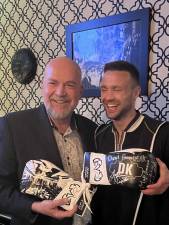 Super lightweight boxer Josh Taylor gives a pair of autographed boxing gloves to DK Restaurant’s owner, Denis Morovi. Photo: DK Restaurant