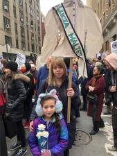 <b>Kimberly Schiller carries a shirtwaist banner with the name of one of the 146 people who died in the Triangle Shirtwaist Factory Fire in 1911 in the biggest fire tragedy in the city’s history. Her daughter Anna Lee carries three white roses. </b> The victims were mostly poor Jewish and Italian immigrants. Photo: Keith J. Kelly
