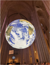 Luke Jerram’s monumental “Gaia” installation hangs aloft in the nave at the Cathedral of St. John the Divine. In Greek mythology, Gaia is the personification of our planet, often referred to as “Mother Earth.”