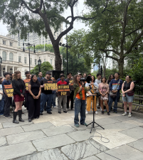 Mina Farahmand addresses the crowd while demonstrating with dozens in front of City Hall in a dispute over unpaid interns in the office of City Council member Harvey Epstein.