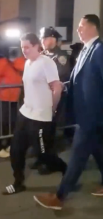 Suspect John Woeltz is escorted by detectives after his arrest. He, along with William Duplessie, allegedly tortured an Italian tourist for nearly three weeks in a bid to obtain his crypto wallet password.