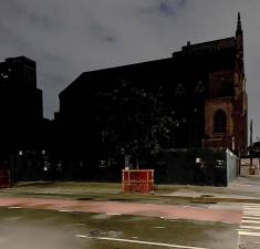 Historic St. Monica's Church on East 79th Street looms inthe background in this view looking east across First Avenue. It'sonly 9 p.m., but the full block near an Extell construction site isdark, desolate and completely deserted.
