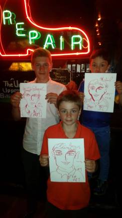 Daniel, 15; Fergus, 11; and Michael, 5, visitors from Ireland with portraits by Walter DeForest, aka #VGFY, who was making an attempt at a portrait-drawing record in preparation for his one-man show, &#8220;Van Gogh Find Yourself.&quot; Photo: #VGFY