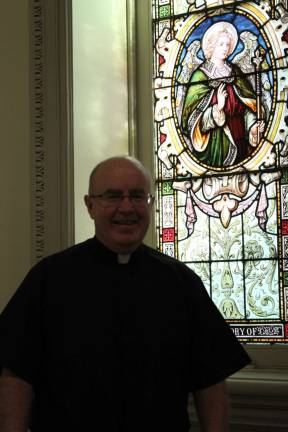 Father Philip Kelly at St. Francis de Sales Catholic Church on East 96th Street, which has seen its parish population grow and attract young professionals and families. Photo by Megan Bungeroth