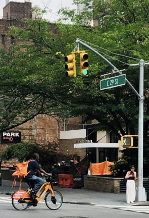 A deliverista runs a red light at the intersection of E. 29th St. and First Ave. E-bike offenses will be a big part of Quality of Life enforcement under the new division, now live in all Manhattan precincts.