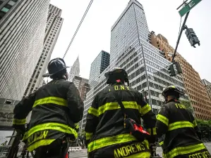 FDNY members wait outside the building at 235 E. 42nd St. where construction workers spotted buckling steel beams and sagging floors that triggered a mass evacuation of that and construction project and surrounding buildings.