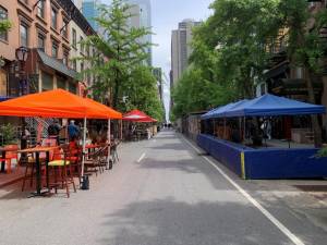 Sidewalk cafes (far left) will be allowed to stay up year round, but sheds such as those in the street on the left and right, must come down in the winter months from November until the end of March. Photo: Ralph Spielman
