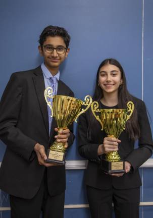 Ronav Shah and Ivy Ponda pose with the team’s championship trophies before an interview at Hunter College High School.