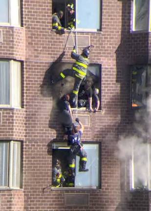 Firefighters save the lives of three victims trapped on the 20th floor of an upper east side high rise using a rope roof rescue on Nov. 5, 2022 after a lithium ion battery attached to a micro charging device erupted. Eight firefighters were honored at the FDNY’s recent Medals Day ceremony. Photo: Courtesy Ken Gunsberger, FDNY