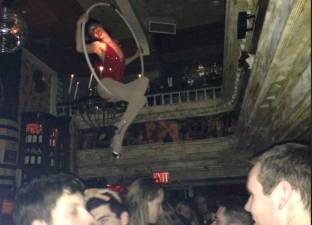 Woman on a trapeze performs above the crowd at The Box, the edgy downtown nightclub that has rotating acts.