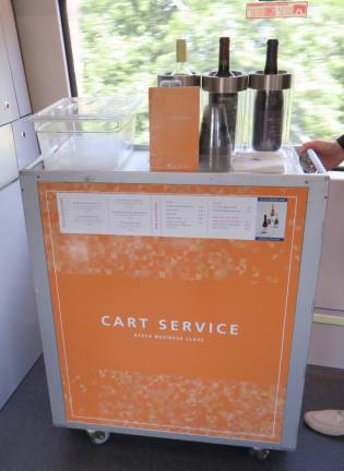 For business-class travelers who want to stay in their seats, this rolling cart will sell them food and beverages as they stay in touch with the office, watch something on their laptop, or savor their travel moments. From pretzels to an antipasto tray, accompanied by an IPA or a San Pellegrino, there should be something a hungry traveler will want.