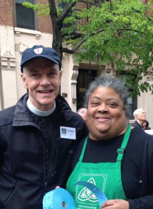 Erlinda Brent (right) with The Church of the Holy Trinity’s rector, The Rev. John Beddingfield, at a street fair in 2016. The church’s street fair event has been on pause since the pandemic. Photo courtesy of Holy Trinity Neighborhood Center Facebook page
