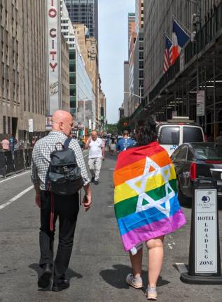 On Their Way To The Parade: A man and a woman draped in a Star of David Gay Pride Flag