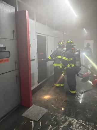 Firefighter wade through smoke in LIRR tunnels under Grand Central Station.