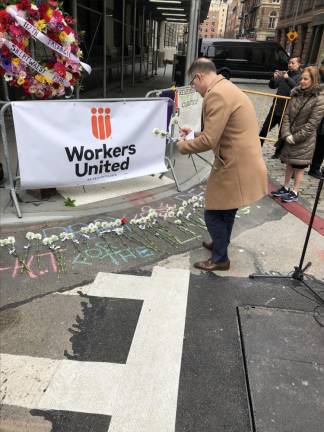 <b>Manhattan Borough President Mark Levine, lays three roses after speaking to the crowd at the corner of Washington St. and Greene Street, where the building that once housed the Triangle Shirt Waist Factory is now owned by NYU.</b> Photo: Keith J. Kelly