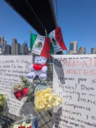 “Rest in Peace Proud Mexican Cadets” reads a sign scrawled in Spanish on a Mexican flag at a makeshift memorial growing on the Brooklyn side of the East River near the site where a tall ship of the Mexican Navy collided with the Brooklyn Bridge after it left the South Street Seaport.