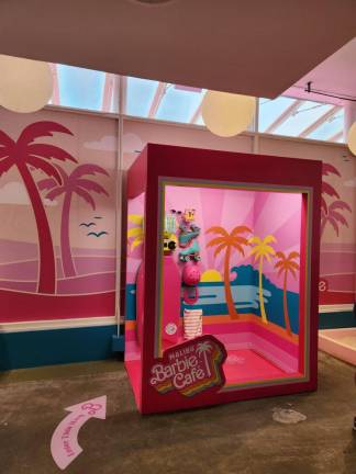 A life-size shadow box with accessories on one side and a place for you to pose on the other is one of many photo ops galore inside the Malibu Barbie Cafe on Fulton St. that allows you to pose with anything from a surfboard to a lifeguard stand. Photo: Instagram/ barbiecafeofficial