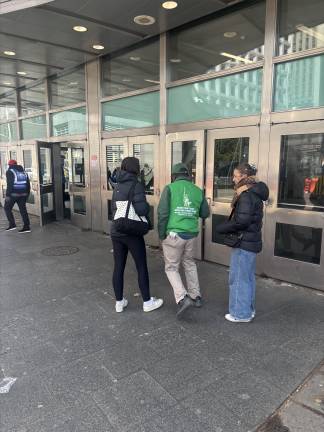 One of the many illegal ticket vendors approaches two young woman outside the Staten Island Ferry entrance. All vendors are technically banned from the Battery Park area, but the NYPD has not taken serious enforcement action, according to Statue City Cruises, the only ticket vendor authorized by the city.