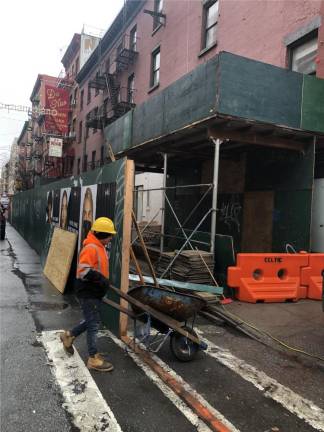 A worker wheels supplies into 188 Grand St. where a chimney and wall had collapsed. The owner has not gotten DOB approval to repair the building rather than demolishing it. Photo: Keith J. Kelly
