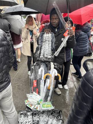 Despite the rain that started during the Easter Parade, the local umbrella salesman said business was only “so so.” Many of the revelers came prepared with their own umbrellas.