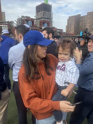 Carlina Rivera holds her son Benny at the Peter Stuyvestant Little League opening-day parade. Looking on to the right is Assembly Member Harvey Epstein, who in June won the Democratic primary to succeed Rivera on the City Council. If he wins, he will be sworn in right after the November election.