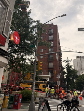 Workers and equipment surround the installation of a tower crane at First Avenue and East 77th Street for the future 89-unit residential development.
