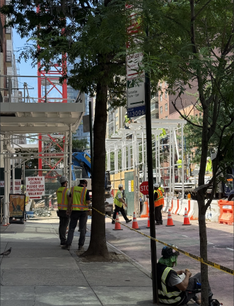 Construction workers assemble steel framework at the 1482-1484 First Ave. development site.