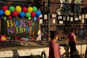 Parents walk past a Back to School welcome sign on the first day of class earlier this month. Photo: Gabby Jones for Chalkbeat