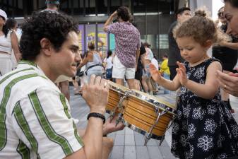 A child interacts with a musician during West Side Fest programming near the Whitney Museum.