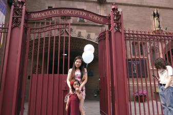 Leslie Wong picks up her daughter Lila who graduated from pre-k on June 16th, on the last day of classes at Immaculate Conception School, which is closing down. Photo: Beau Matic