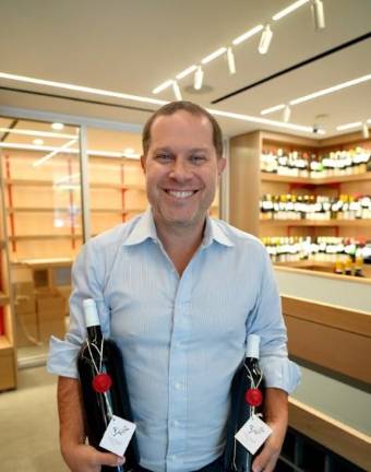 McCabes Wine &amp; Sprits owner Daniel Mesznik holds two bottles of kosher wine. The shop, an UES staple for 50 years, reopened last month after a 16-month renovation, featuring an extensive collection of curated wines and a tasting bar.