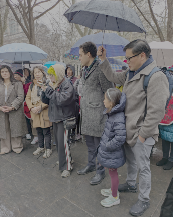 State Sen. Ron Kim and dad of three daughters on umbrella duty at Christopher Marte rally to protect home health aide workers. State Sen. Jessica Ramos left.