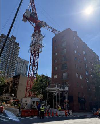 A newly installed tower crane looms above neighboring buildings at the site of the future 30-story residential tower at 1482-1484 First Ave.