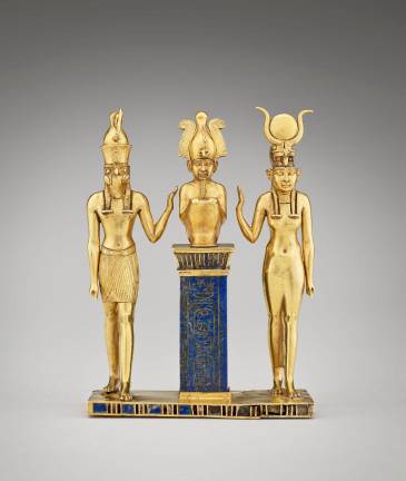 From “Divine Egypt,” at the Met: Statuette of falcon-headed Horus, seated Osiris, and Isis, wearing sun disk and horns. Made of glass, gold, and lapis lazuli, it dates from ca. 872 to 837 BCE. About 4 inches tall, it is on loan to the Met from the Musée du Louvre.