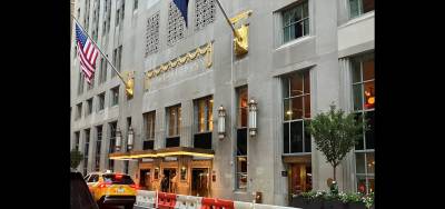 Lexington Avenue entrance of the Waldorf Astoria hotel’s landmarked exterior, with the two-story Lex Yard restaurant gleaming behind the windows on the right.