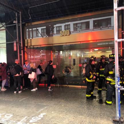 Office dwellers wait under scaffolding after being forced to evacuate 500 Eighth Ave. due to smoke in basement caused by floodwaters. Photo: Keith J. Kelly
