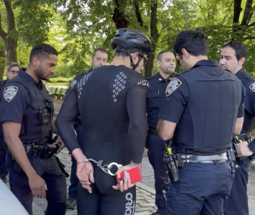 Biker handcuffed and arrested in Central Park back in May, right after the NYPD started cracking down on cyclists. Police had no info on what prompted the handcuffing, although some posters on a subreddit site where the photo appeared said the biker was later uncuffed.