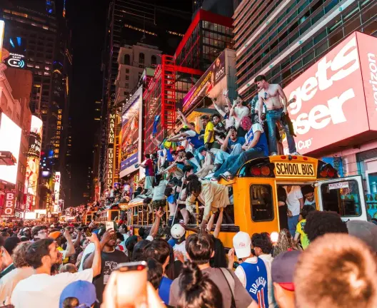 Fans climbed atop five school buses that were set aside to transport people from Manhattan to the World Cup games. One of the buses was later set on fire near Times Square. There were 65 arrests on the night,.