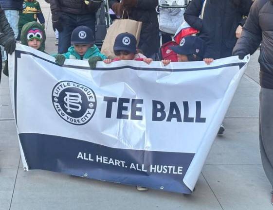 The youngest baseball players carry the Tee Ball sign at the opening day parade of the Peter Stuyvesant Little League on March 28. The league draws players from a catchment area that runs from the East Village to the UES.
