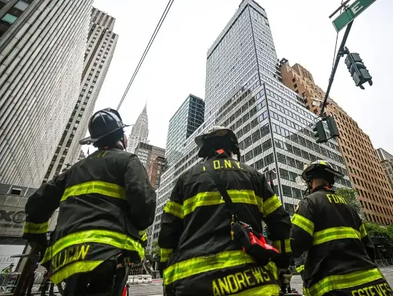 FDNY members wait outside the failing building.