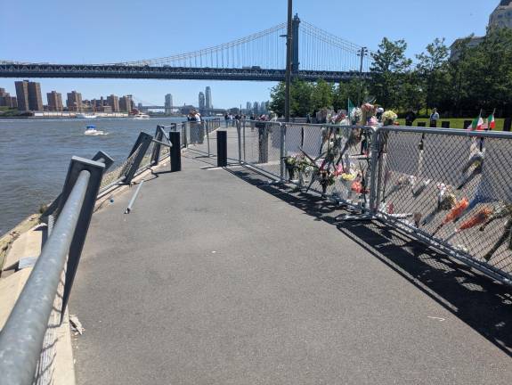 A memorial was growing on the chain-link fence put up in front of the railing that was damaged when the Mexican Navy training ship Cuauhtemoc crashed into a Brooklyn waterfront park after colliding with the underside of the Brooklyn Bridge. Two cadets were killed.