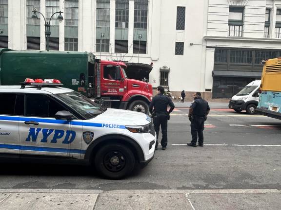 Two police officers stand on West 34th street as police stepped up their presence on the problem plagued street after a deadly crash on Sept. 28 when a dump truck struck a woman on a delivery bike.