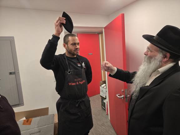 The owner of McCabe’s Wine &amp; Spirits, Daniel Mesniak (left) signs his business over to an associate for the duration of Passover. The transaction is blessed by Rabbi Kalman Weinfeld