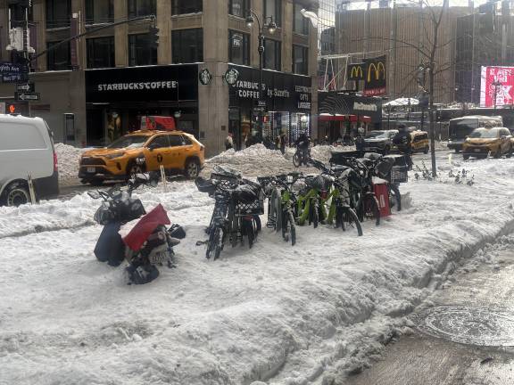 Delivery bikes encased in snow on 8th Ave. and 35th St. in Chelsea on the day after the storm on Jan. 26.
