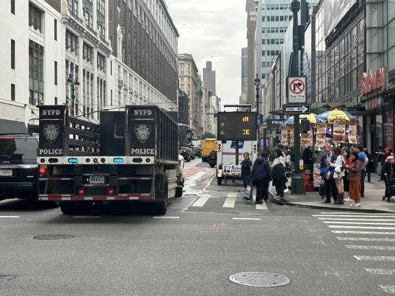 An NYPD police truck drives towards a very busy intersection near Penn Station.